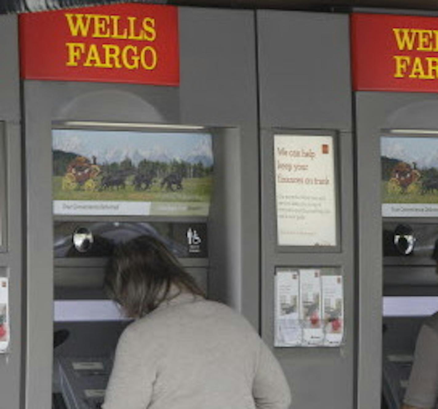 FILE - In this April 18, 2011 file photo, customers use Wells Fargo Bank ATM machines in Santa Clara, Calif. JPMorgan Chase, Bank of America, Wells Fargo, Bank of New York Mellon and State Street were cited Wednesday, April 13, 2016 by the Federal Reserve and the Federal Deposit Insurance Corp. for gaps in their bankruptcy plans known as "living wills" that they were required to submit. The five banks were among eight Wall Street behemoths whose plans were evaluated. (AP Photo/Paul Sakuma)