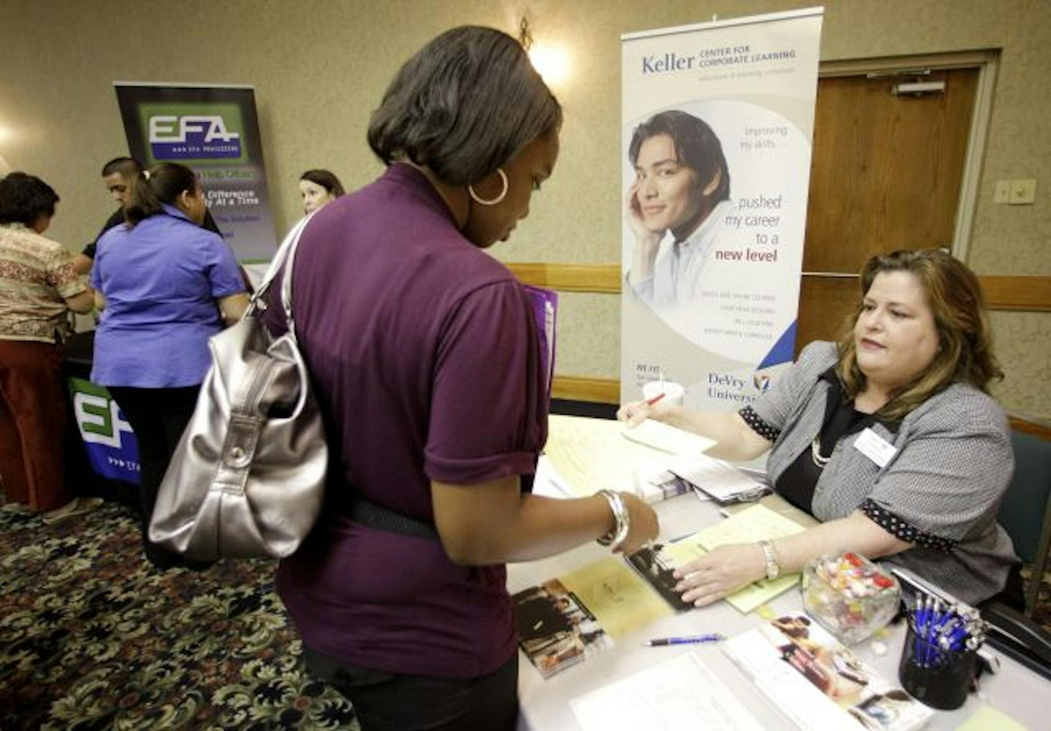 In this photograph taken July 20, 2010, LaPorscha Armstrong, left, meets with Nancy Wetmore, right, manager of local accounts with Keller Center for Corporate Learning during a National Career Fairs Job Fair, in Plano, Texas. Initial requests for jobless benefits rose last week to their highest level since April, a sign that hiring remains weak and some companies are still cutting workers.