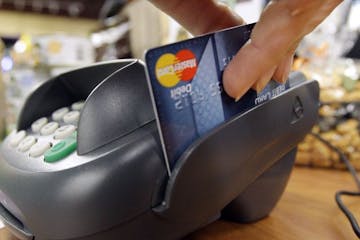 FILE - In this Nov. 2, 2009 file photo, a customer swipes a MasterCard debit card through a machine while checking-out at a shop in Seattle. Bankers a