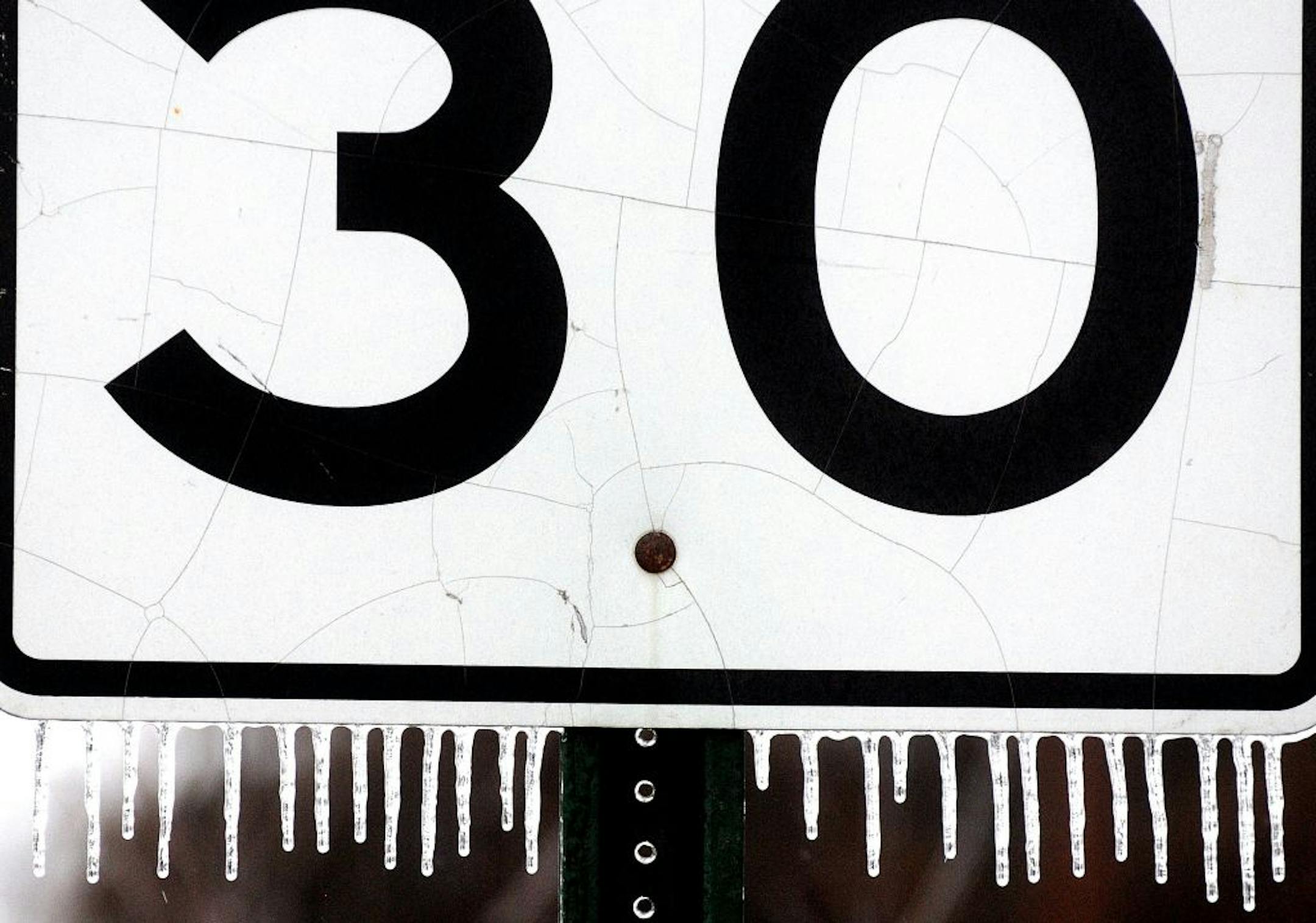 Ice accumulates on a speed limit sign on Second Street in Winona, Minn., on Jan. 27, 2013.