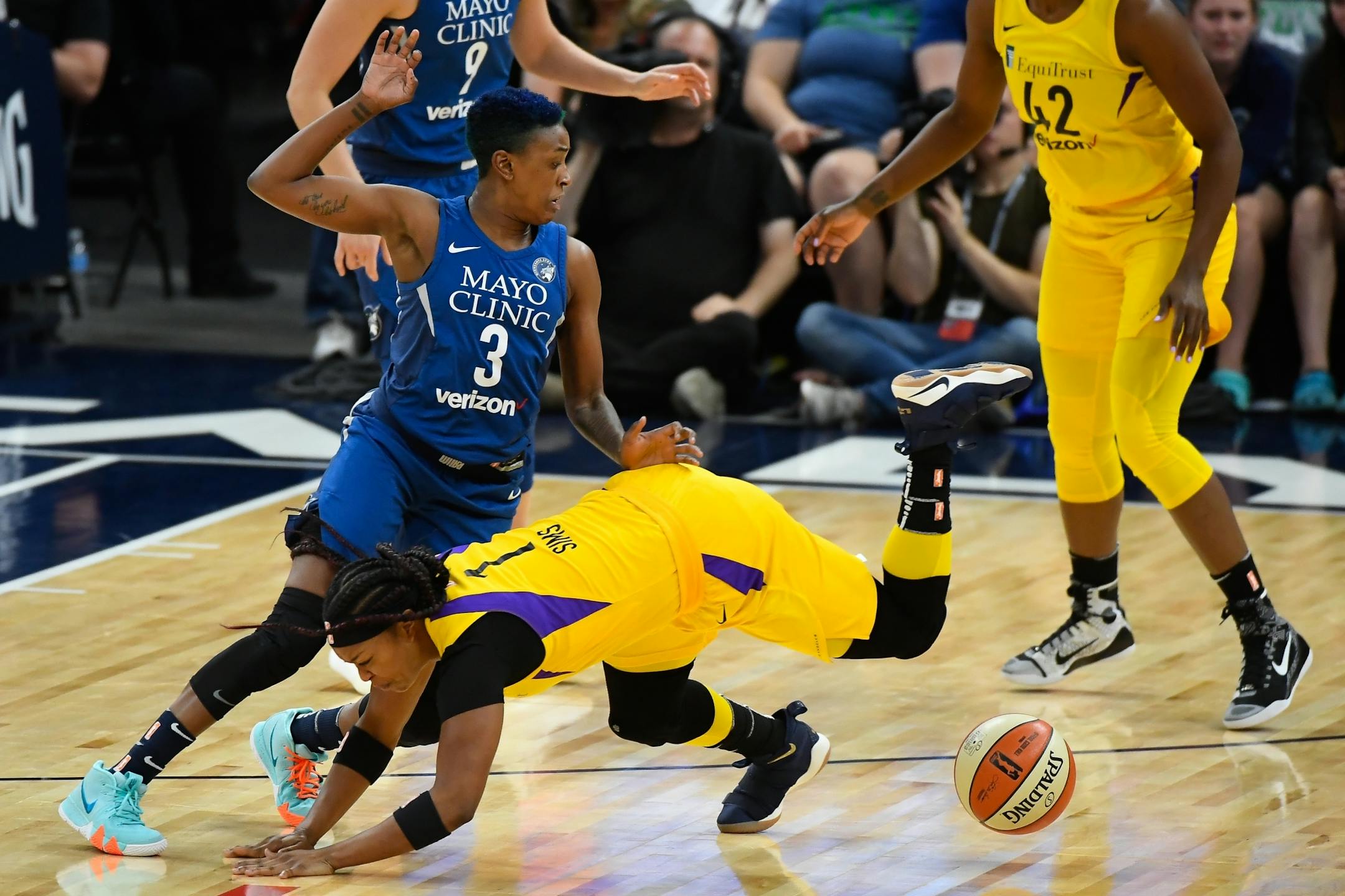 Los Angeles Sparks guard Odyssey Sims (1) was knocked off her feet as Minnesota Lynx guard Danielle Robinson (3) stripped the ball from Sims in the first quarter.