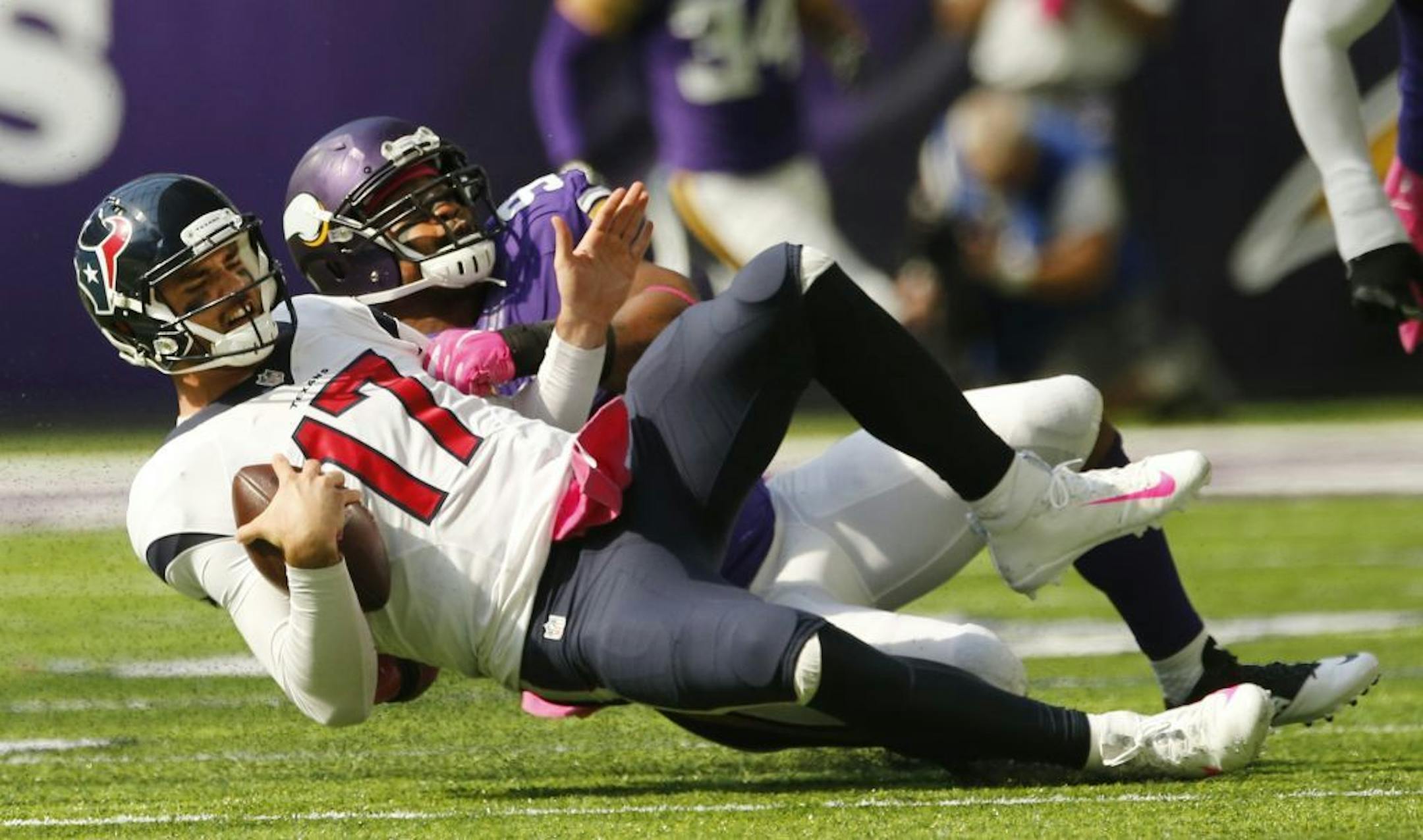 Houston Texans quarterback Brock Osweiler (17) is sacked by Minnesota Vikings defensive end Everson Griffen, rear, during the first half of an NFL football game Sunday, Oct. 9, 2016, in Minneapolis.