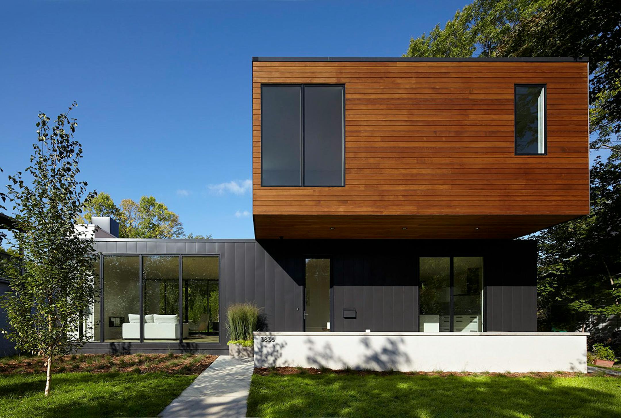 The modern home's flat-roof, scale and simple materials creates a low-key silhouette in a neighborhood of primarily older traditional houses, designed by Peterssen/Keller Architecture.