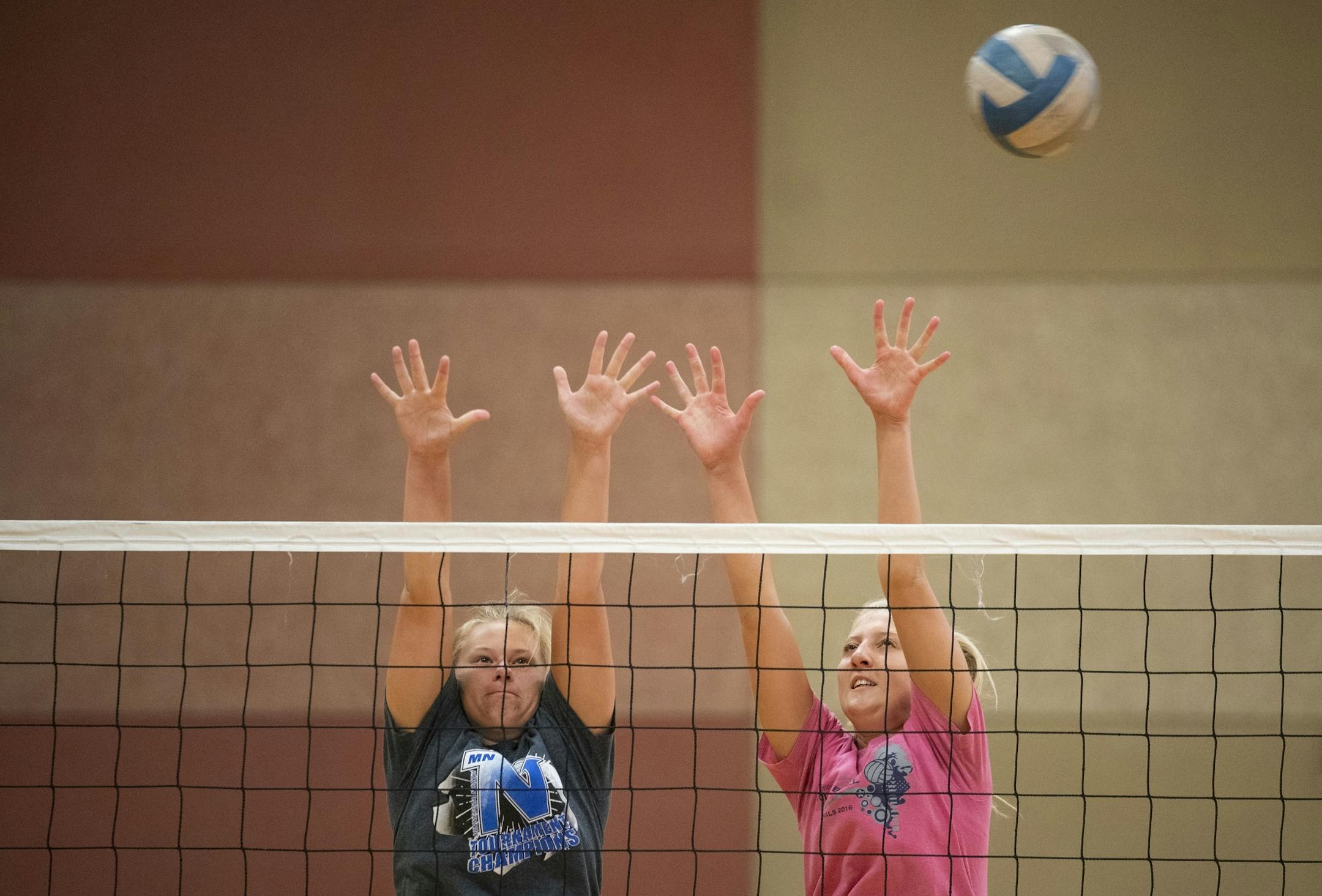 (Left) Sydney Larson and Alli Ahlers jumped up to block a spike during Denfeld High School girl's volleyball practice in Lincoln Park Middle School on Tuesday. Girl's volleyball has been moved to the spring for the 2020-21 school year.