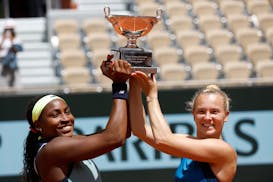 Coco Gauff of the U.S., left, and Katerina Siniakova of the Czech Republic pose with the trophy as they won the women's doubles final match of the Fre
