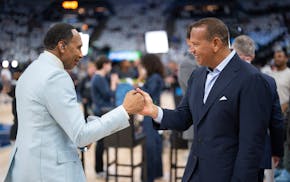 ESPN sports analyst Stephan A. Smith shakes hands with Minnesota Timberwolves co-owner Alex Rodriguez before Game 3 on Saturday of the Western Confere