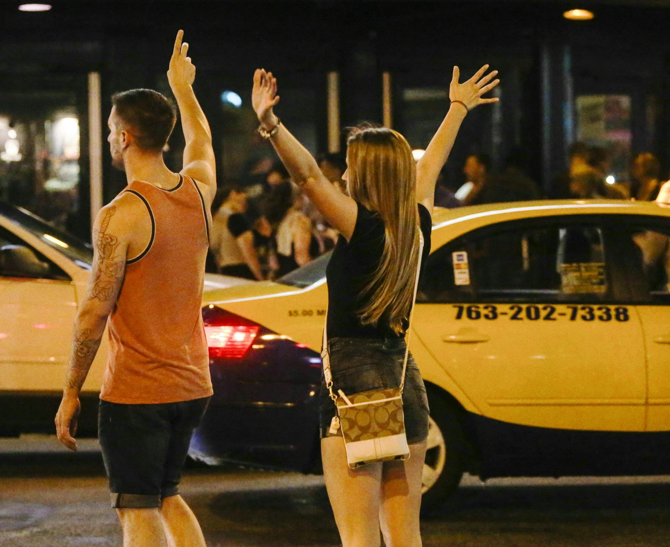 After bar closing at 2 a.m., two people try to hail a taxi near First Avenue Saturday, June 28, 2014, in downtown Minneapolis.