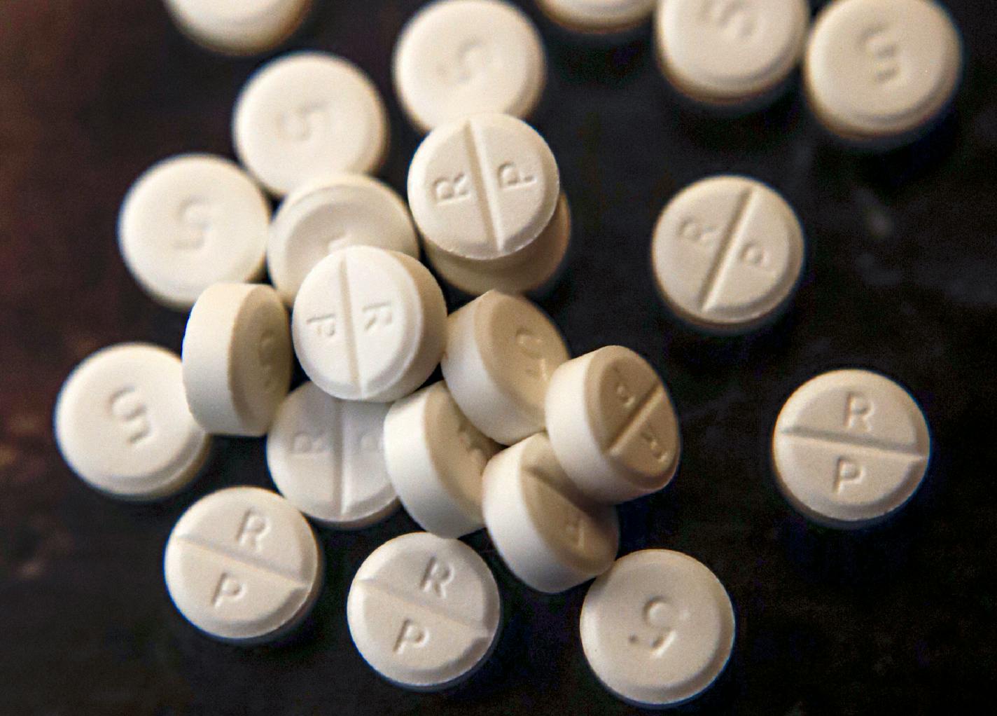 FILE - This Monday, June 17, 2019, file photo shows 5-mg pills of Oxycodone. While the nation's attorneys general debate a legal settlement with Purdue Pharma, the opioid epidemic associated with the company's blockbuster painkiller OxyContin rages on. The drugs still kill tens of thousands of people each year with no end in sight. (AP Photo/Keith Srakocic, File)