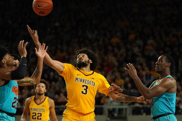 Gophers forward Jordan Murphy reached out to grab a loose ball in the first half Friday night vs. Oklahoma State at U.S. Bank Stadium.