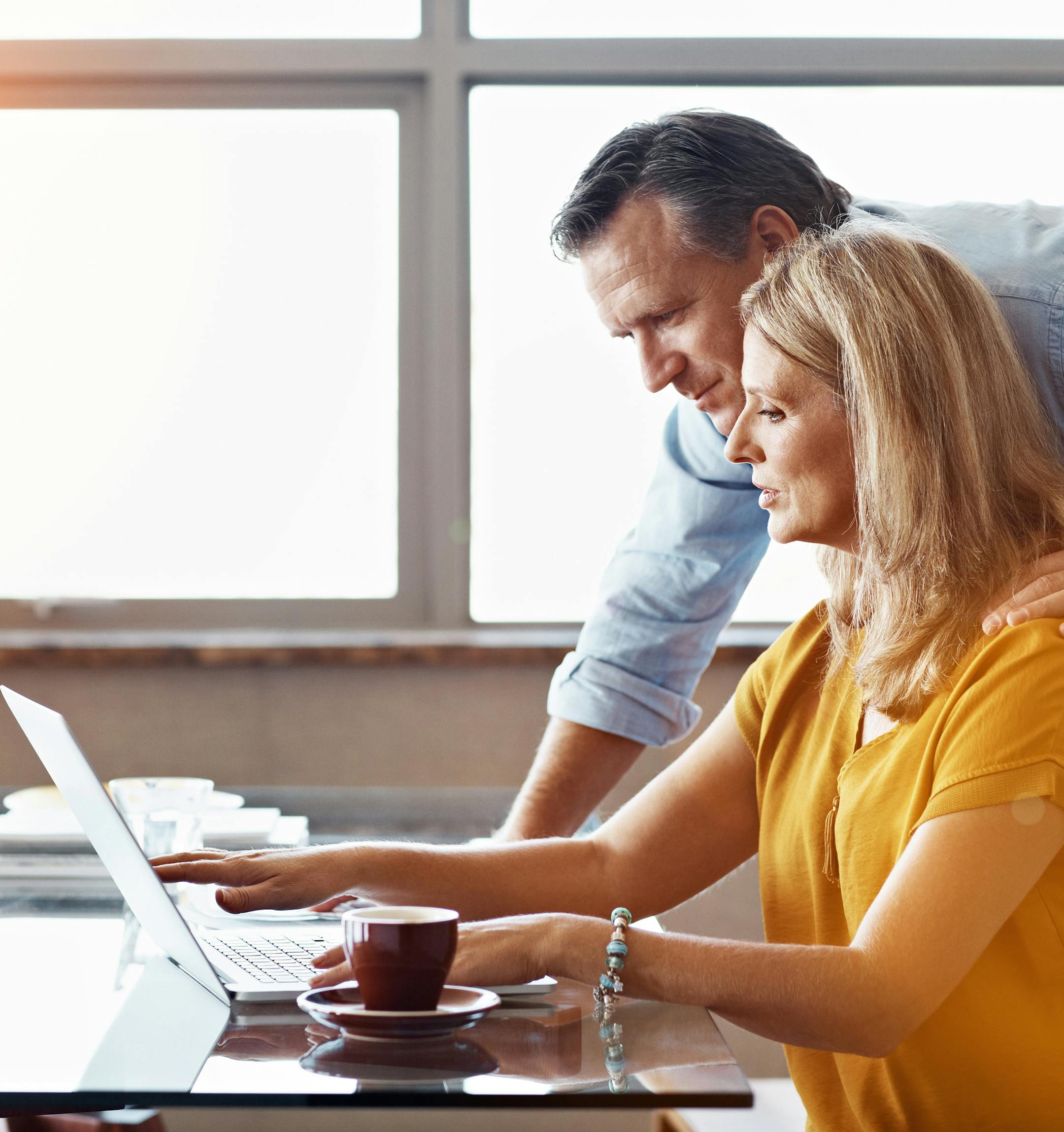 Shot of a mature couple sitting at their dining room table doing online banking using a laptop. istock