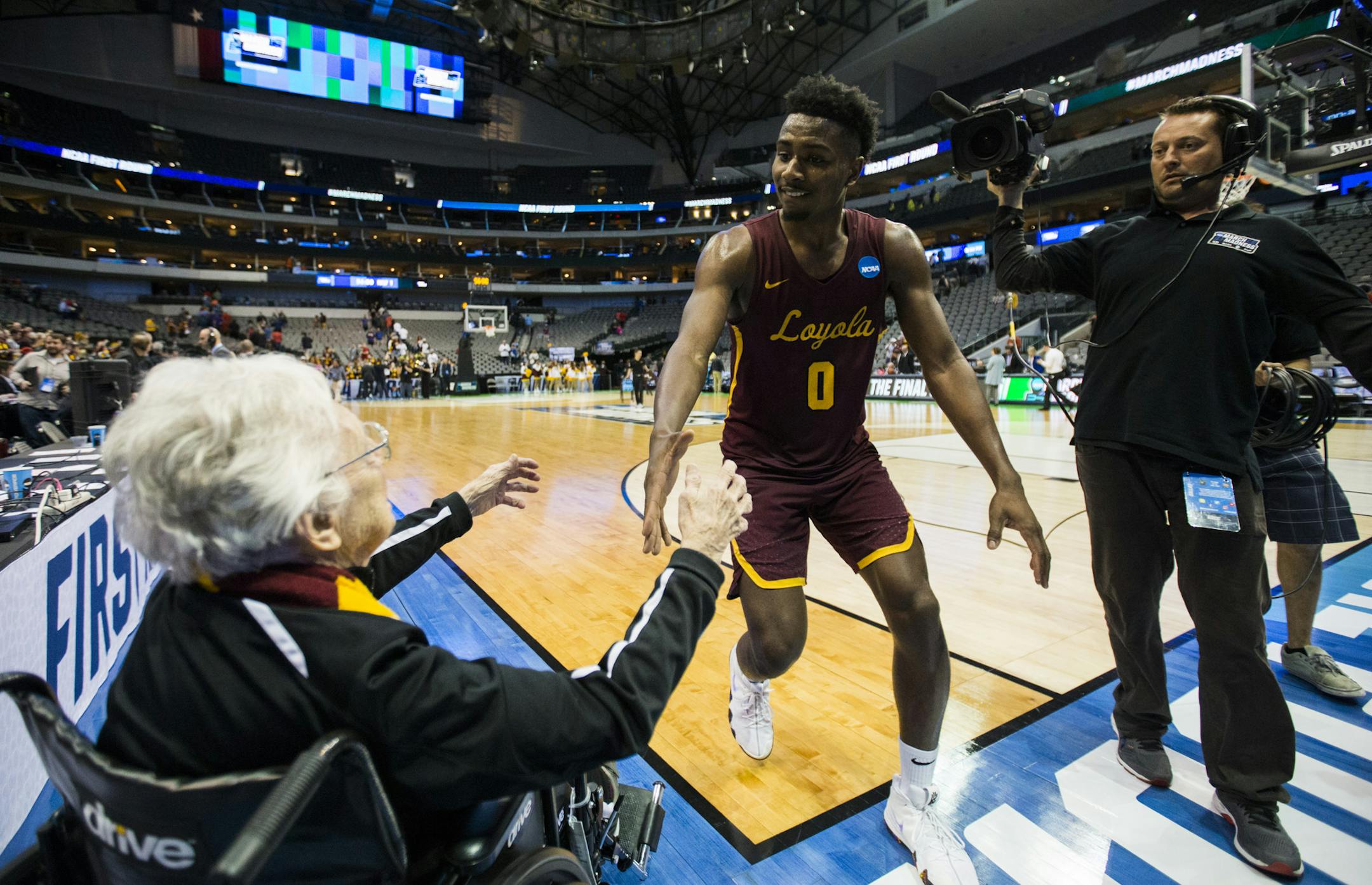 Sister Jean Dolores-Schmidt, a 98-year-old nun and Loyola Ramblers superfan, celebrates with Loyola's Donte Ingram (0) and the team on the court after a 64-62 win against Miami in the first round of the NCAA Tournament on Thursday, March 15, 2018, at the American Airlines Center in Dallas. (Ashley Landis/Dallas Morning News/TNS) ORG XMIT: 1226152