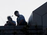 A police officer fires a rubber bullet from atop the Minneapolis Police Third Precinct station during  unrest following the May 2020 murder of George 