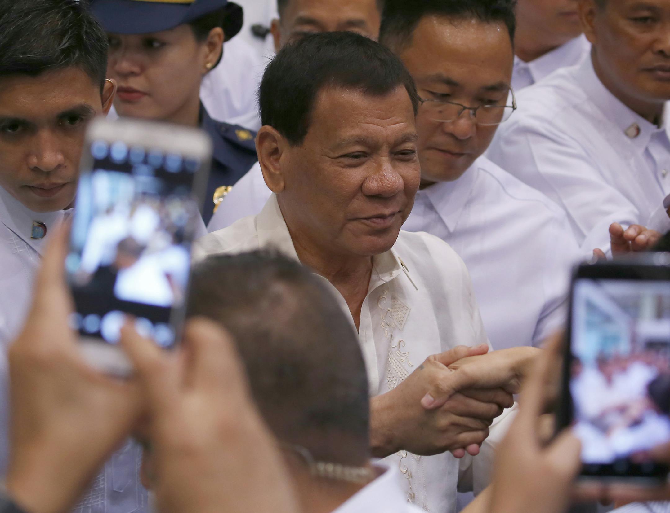 Philippine President Rodrigo Duterte greets stock traders during his visit for the first time at the Philippine Stocks Exchange to mark the 10th anniversary of the stock listing of Phoenix Petroleum at the financial district of Makati city, east of Manila, Philippines, Tuesday, July 11, 2017. Duterte said a disastrous siege by Islamic State group-aligned gunmen on a southern city of Marawi may end in 10 to 15 days but the threat posed by the brutal group will continue to plague the country. (AP