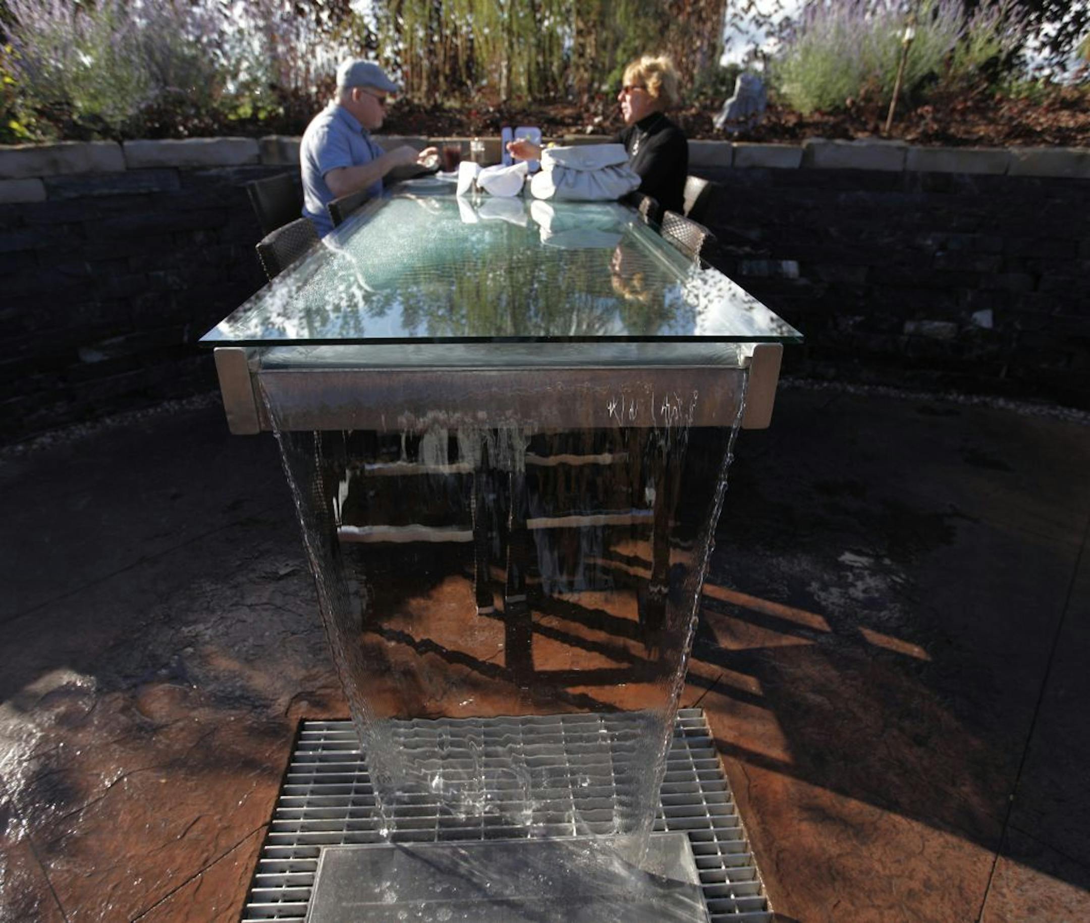 Jeff and Mary Jo Radaj enjoy the waterfall table on the patio of Porter Creek Hardwood grill in Burnsville. It had a pleasant white noise effect on restaurant and road noise.
