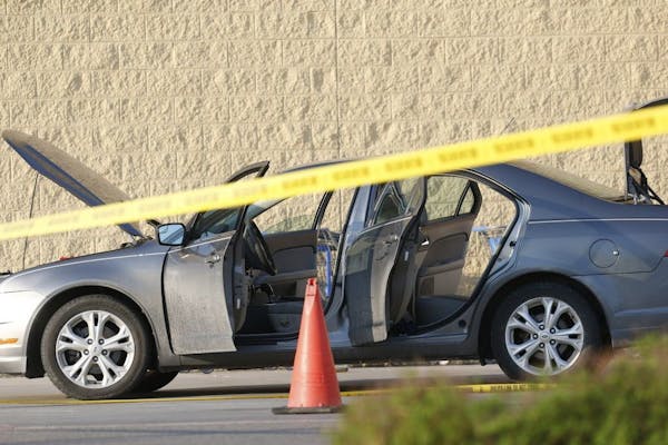 A car was investigated and searched near the entrance of Wal-Mart at the scene of a shooting on Tuesday, May 26, 2015, in Grand Forks, N.D.