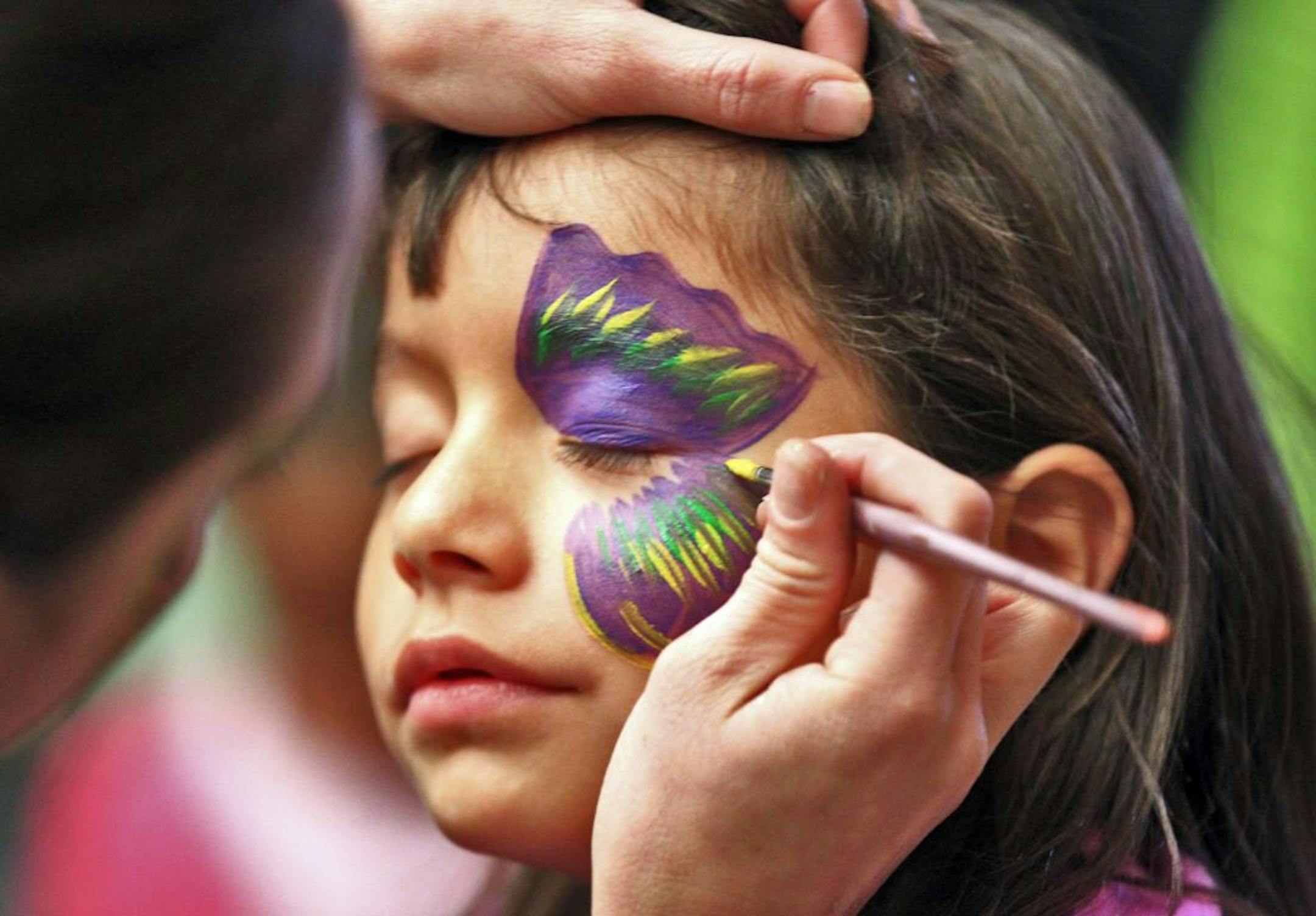 A Celebrate Adoption event was held at the Prom Center in Oakdale Sunday, where over 500 children adopted from foster care and their parents were treated to games, face painting, an animal zoo, and pony rides. Arianna Wright, 6, of West St. Paul and an adopted child of parents Edgar and Jennifer Wright of West St. Paul, received a butterfly face painting design. (MARLIN LEVISON/STARTRIBUNE(mlevison@startribune.com