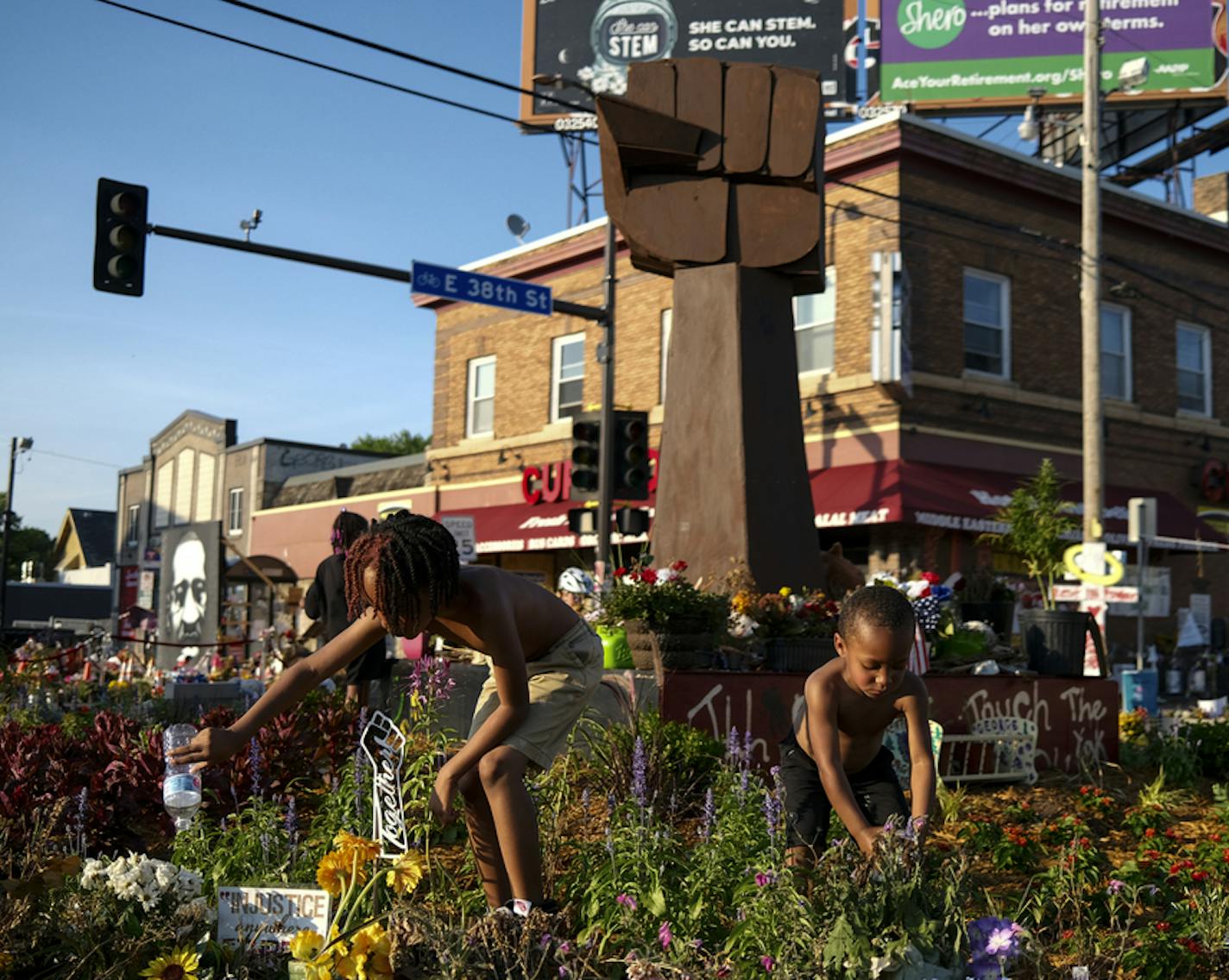 Mister Smith, 7, and his little brother, Sir'Miles Smith, 4, watered the plants at the memorial in the 38th and Chicago intersection near where George Floyd was killed in Minneapolis Police custody in late May. ] aaron.lavinsky@startribune.com People visited George Floyd's memorial outside Cup Foods, where he was killed in Minneapolis police custody in late May, on Saturday, July 4, 2020 in Minneapolis, Minn.