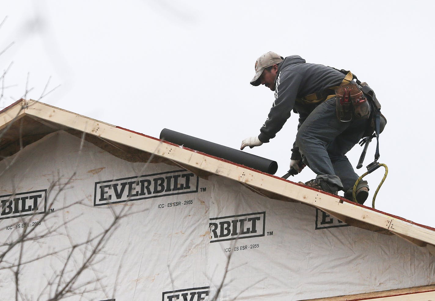 In this Tuesday, Jan. 26, 2016, photo, a man installs a roof on a new home under construction in Atlanta. On Tuesday, Feb. 16, 2016, the National Association of Home Builders/Wells Fargo releases its February index of builder sentiment. (AP Photo/John Bazemore)