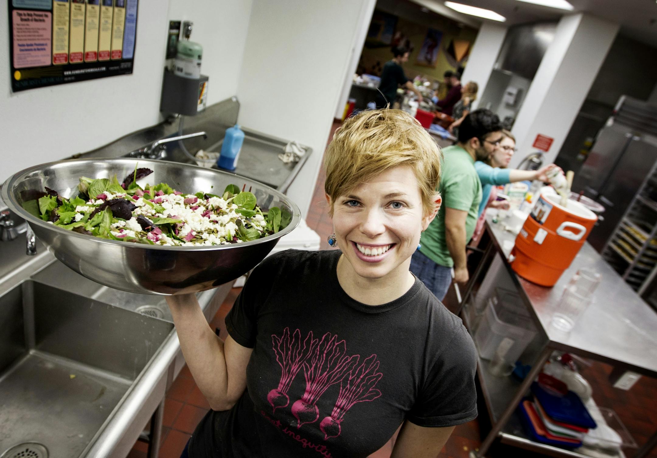 Emily Torgrimson holds a salad at Eat for Equity's community feast benefitting Urban Ventures at the Urban Ventures headquarters in Minneapolis January 31, 2015.