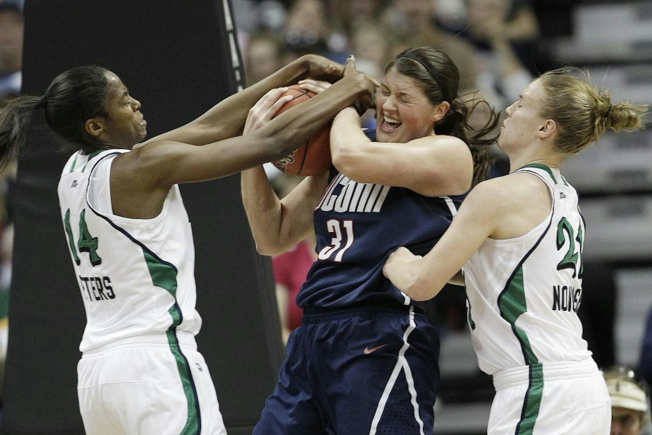 Notre Dame forward Devereaux Peters (14) and Notre Dame guard Natalie Novosel (21) vie for a lose ball against Connecticut center Stefanie Dolson (31) earlier this month.