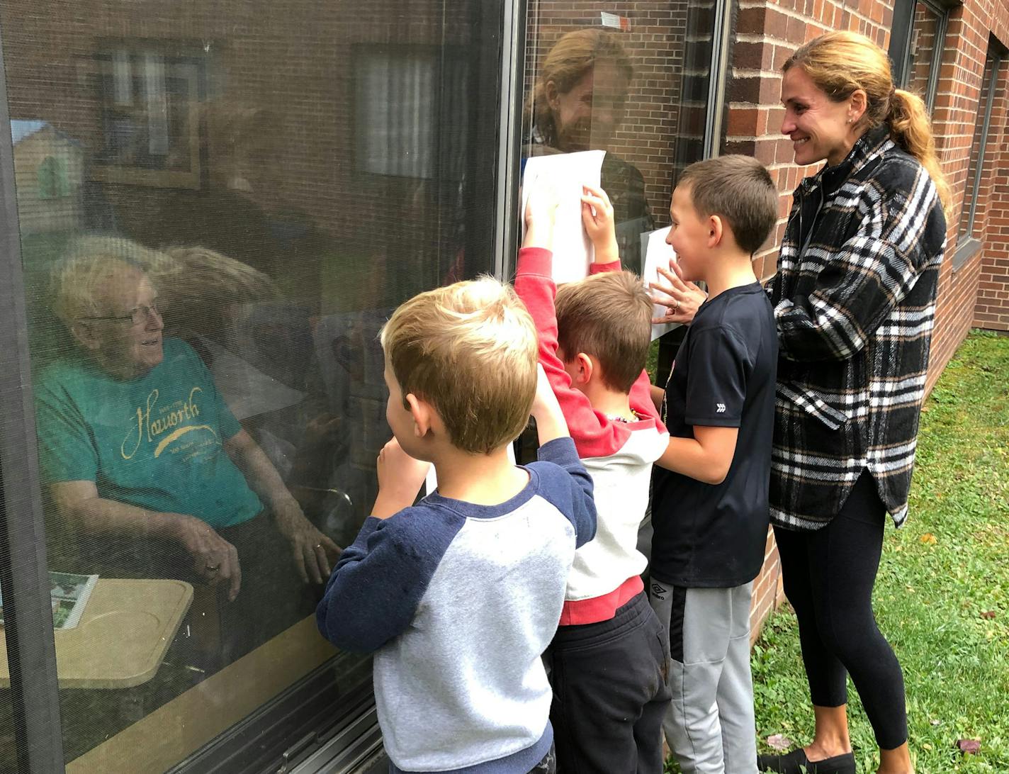 Kara Goucher, right, with son Colt, 10, and nephews Luka and Lachlan Grgas visited her grandfather Calvin Haworth at the hospital as he battled COVID-19. The 96-year-old Haworth died Tuesday.