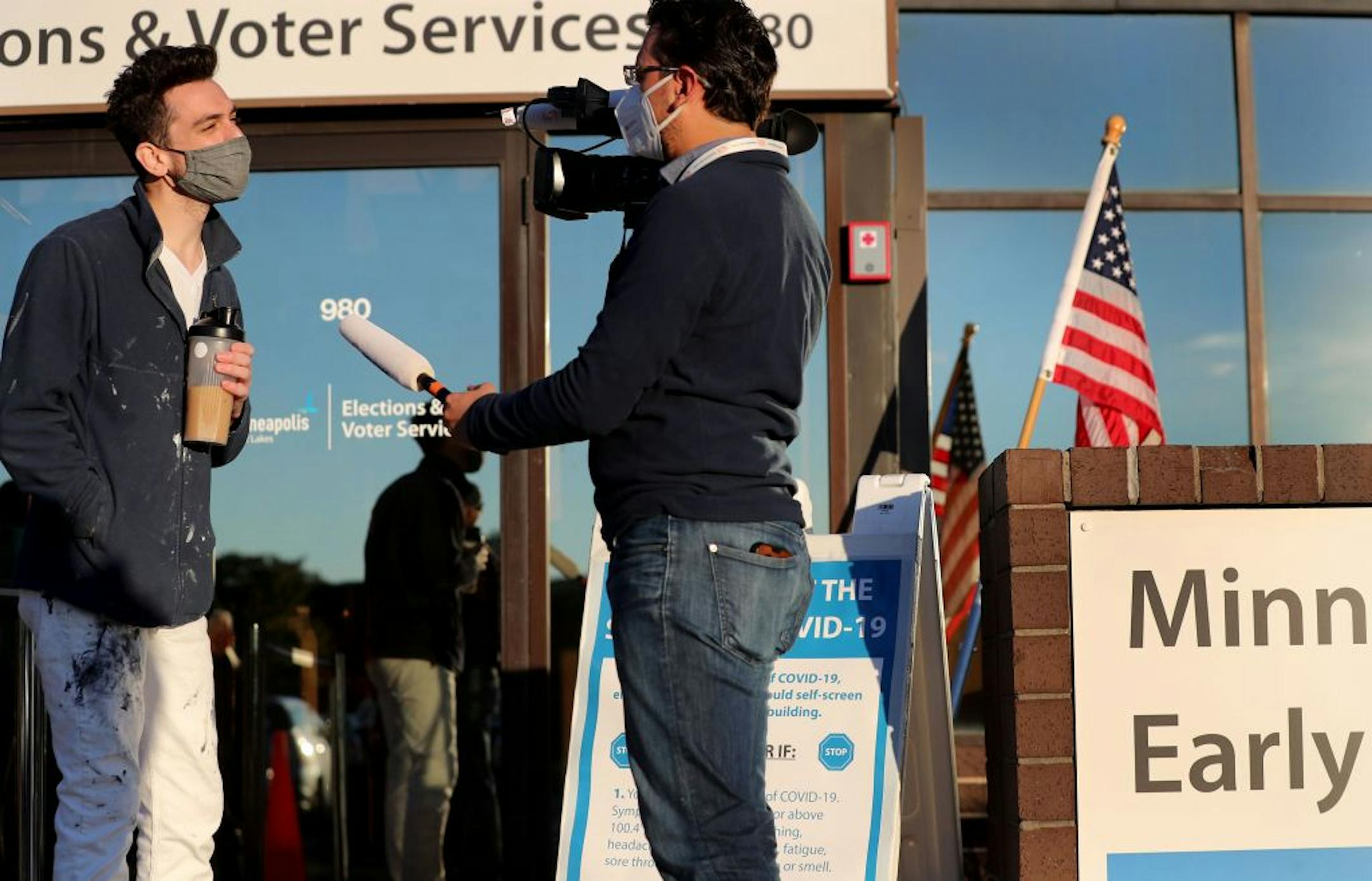 Jason Miller of Minneapolis, who was the first in line for early voting, is interviewed while waiting to vote at Minneapolis Elections and Voter Services Friday in Minneapolis.
