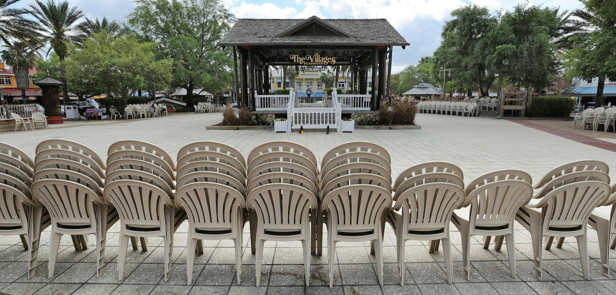 In The Villages, Fla., chairs stacked in a deserted town square at Lake Sumter Landing, Monday, March 23, 2020. All of the swimming pools and fitness facilities operated by The Villages are closed in response to the coronavirus pandemic. (Joe Burbank/Orlando Sentinel/TNS) ORG XMIT: 1614192
