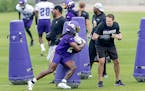 Vikings Head Coach Kevin O'Connell, right, helps with drills and waits for running back Alexander Mattison to round the pads during practice at the TC