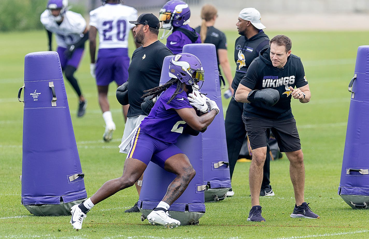 Vikings Head Coach Kevin O'Connell, right, helps with drills and waits for running back Alexander Mattison to round the pads during practice at the TCO Performance Center in Eagan, Minn., on Tuesday, June 6, 2023.