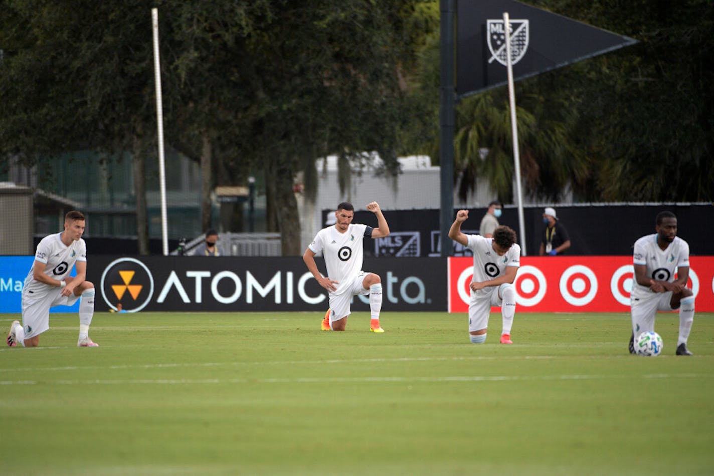 Minnesota United players kneel on the field before an MLS soccer match against Sporting Kansas City.