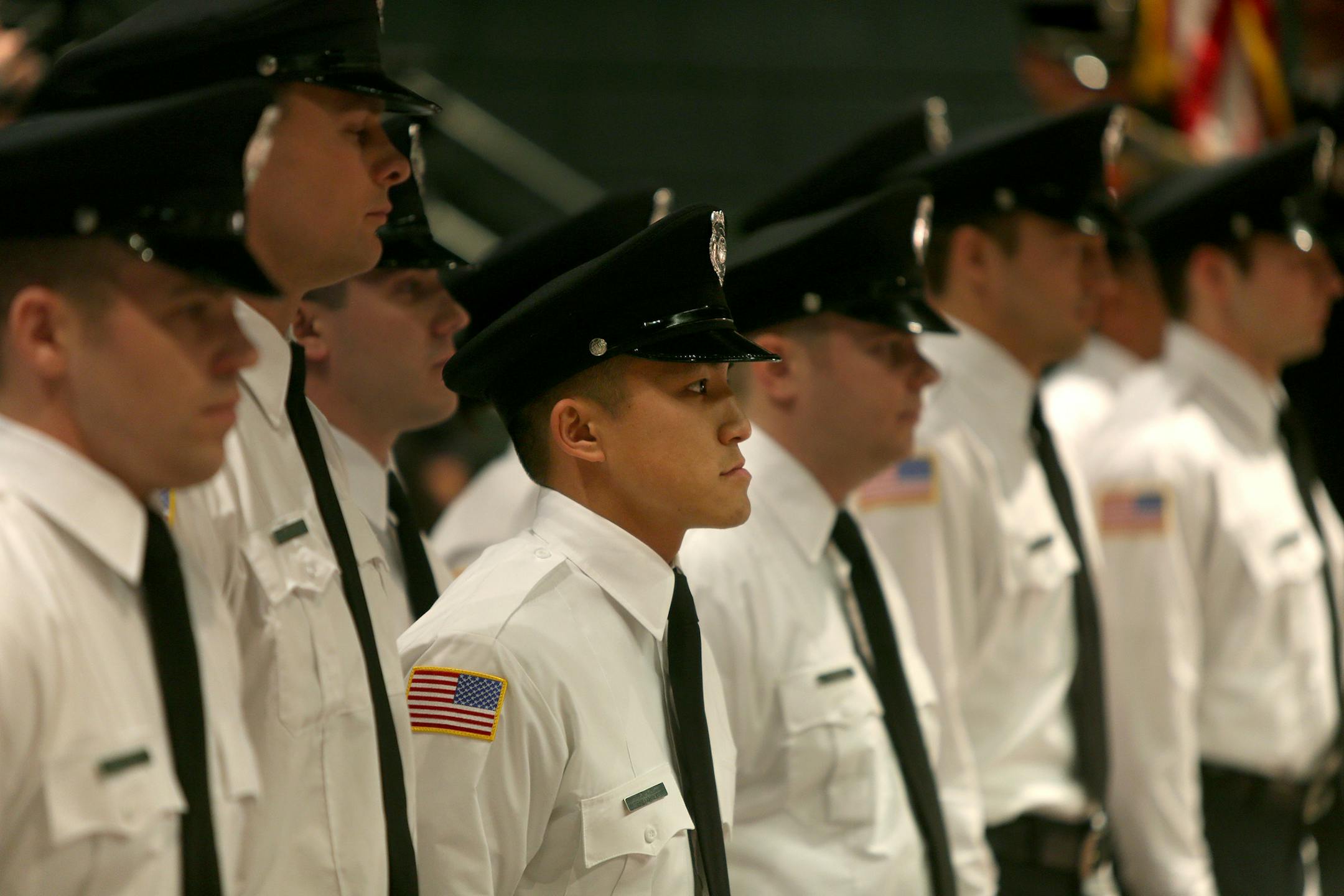 Badges were in place at the St. Paul Fire Department's graduation ceremony at the Paul and Sheila Wellstone Center, Friday, January 3, 2014 in St. Paul, MN. The class included 13 graduates and Tou Lo, center, the first Hmong firefighter in St. Paul. ELIZABETH FLORES/STAR TRIBUNE) ELIZABETH FLORES &#x2022; eflores@startribune.com