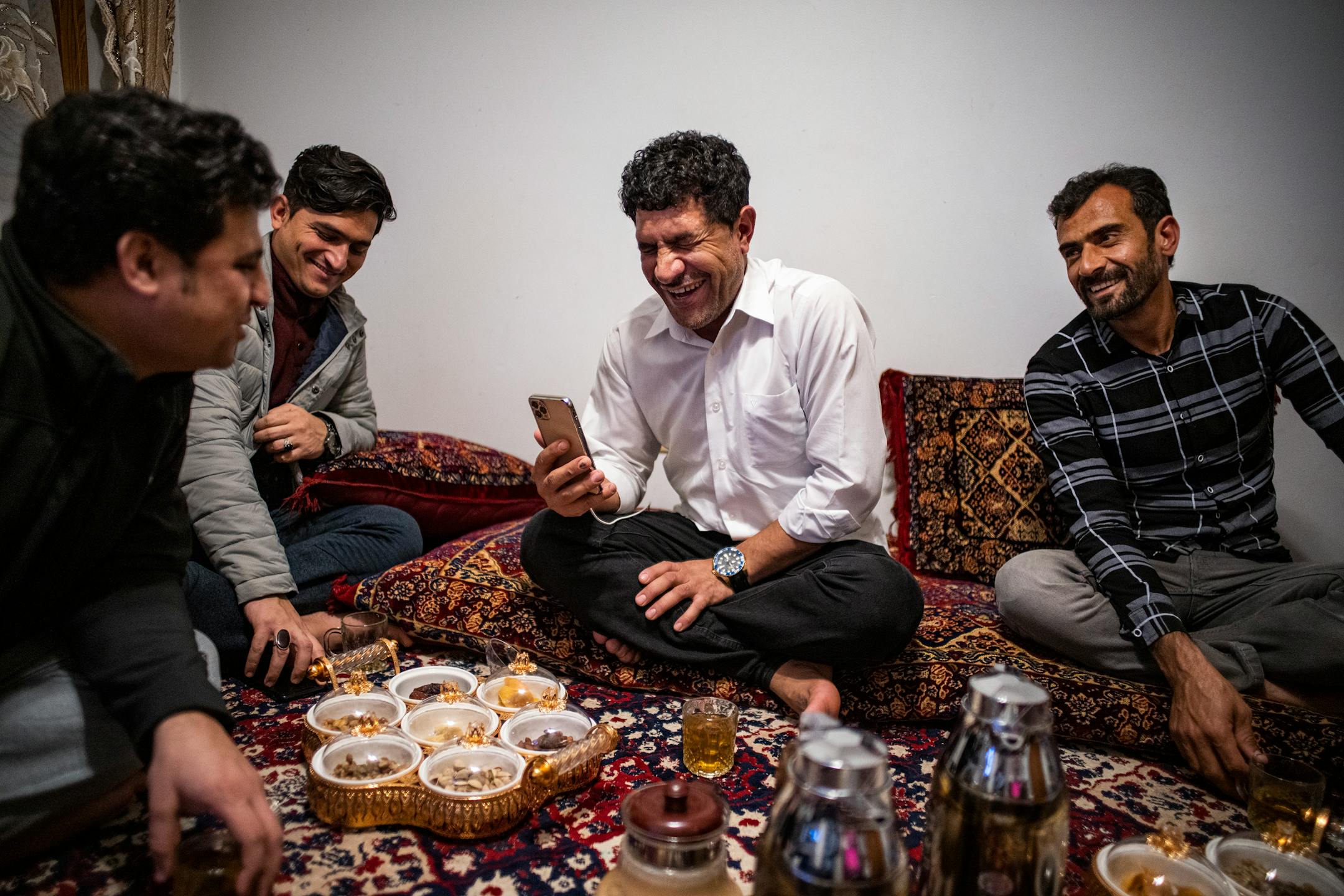 Khyber Malikzai, left, his newly immigrated brother Fahim, Sher Mulakhail and his newly arrived close friend Mirwais Momand enjoy tea and talking to each other in Bloomington.