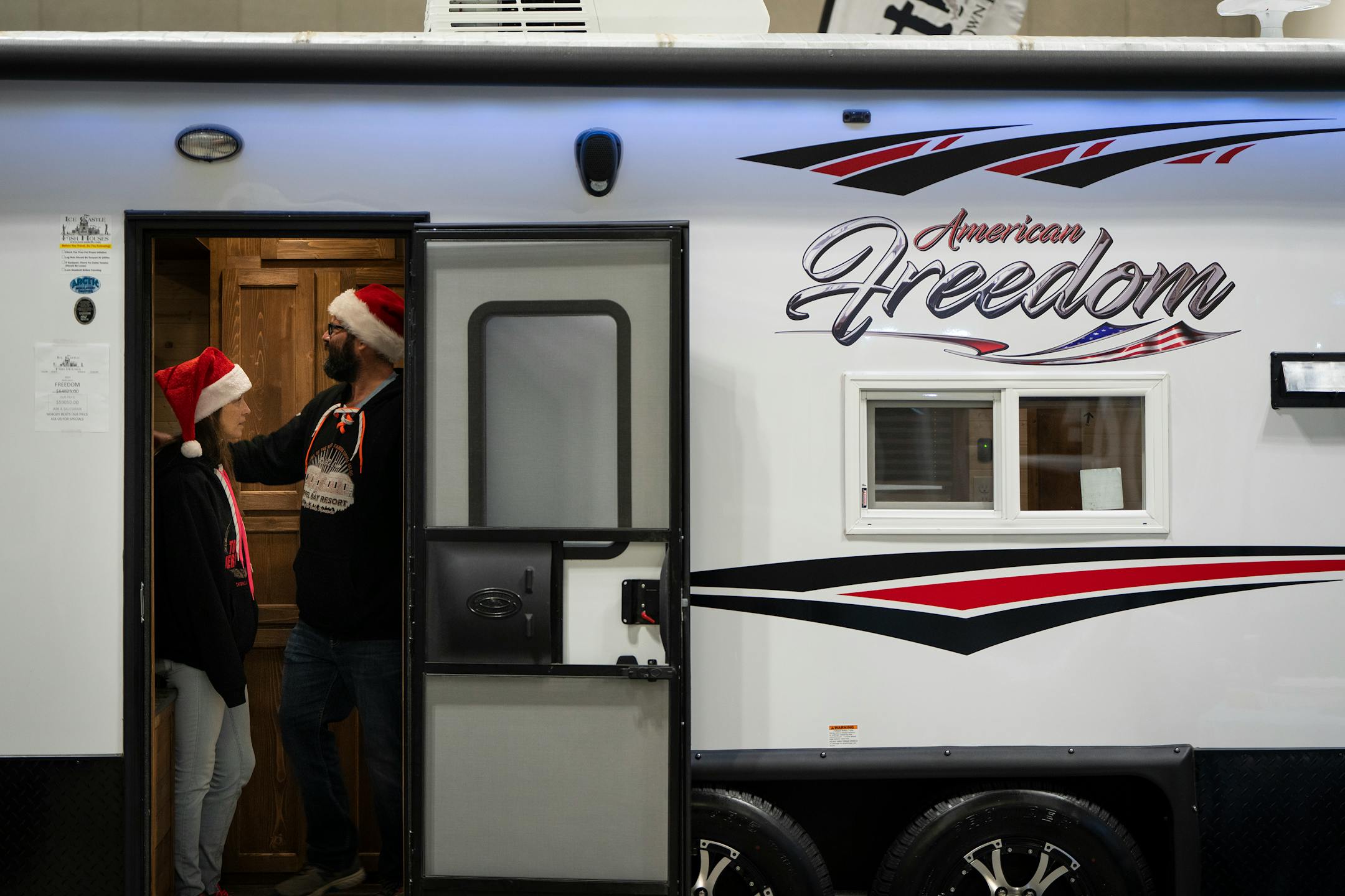 Megan Kearney, left, and Travis Robinette of Farmington check out an American Freedom trailer at the St. Paul Ice Fishing and Winter Sports Show in St. Paul, Minn. Friday, Dec. 1, 2023. ] LEILA NAVIDI • leila.navidi@startribune.com