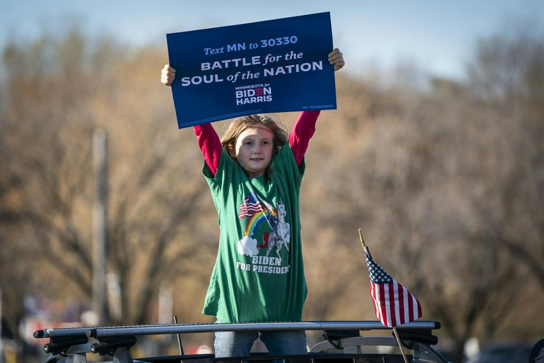 Charlotte Candee, 8, of Minneapolis danced while standing out the sunroof of a car before former Vice President Joe Biden spoke during a drive-in campaign event in Falcon Heights.