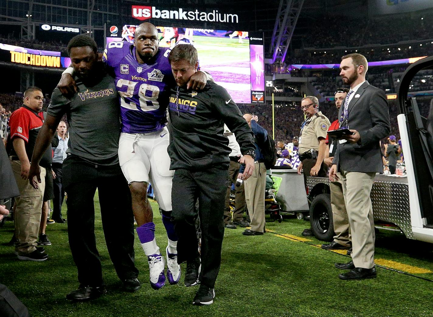 Minnesota Vikings running back Adrian Peterson (28) was helped back to the locker room in the third quarter after leaving the game.