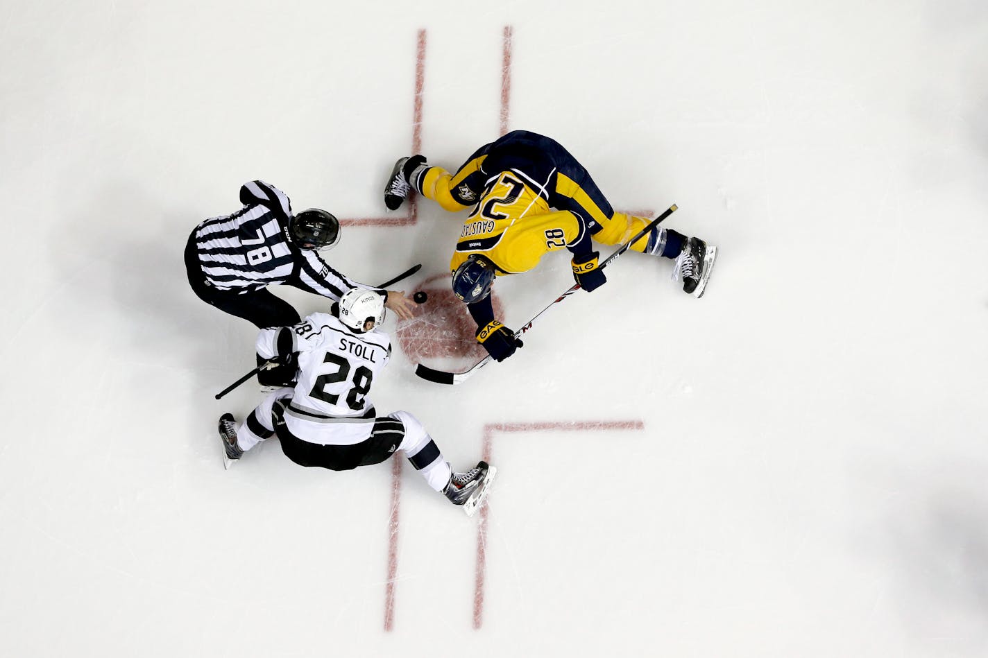 Linesman Brian Mach (78) drops the puck for a face-off between Los Angeles Kings center Jarret Stoll and Nashville Predators forward Paul Gaustad, right, in the first period of an NHL hockey game Saturday, Dec. 28, 2013, in Nashville, Tenn. (AP Photo/Mark Humphrey) ORG XMIT: OTK