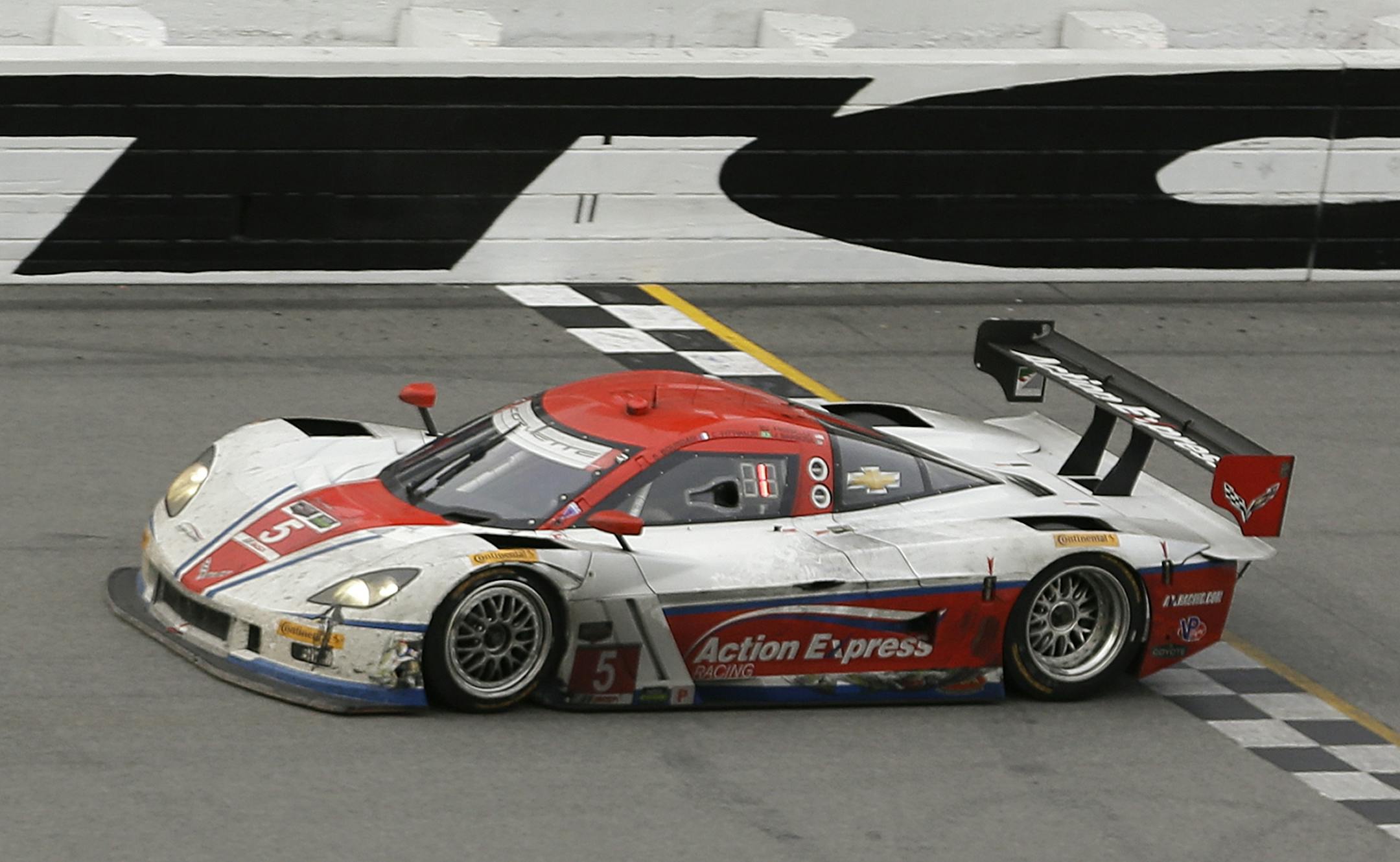 Joao Barbosa, of Portugal, drives the Action Express Corvette DP to the finish line to win the IMSA Series Rolex 24 hour auto race at Daytona International Speedway in Daytona Beach, Fla., Sunday, Jan. 26, 2014.