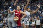 Washington Mystics' Kristi Oliver gets tangled between Lynx' Sylvia Fowles, left, and Lexi Brown to draw a foul during the third quarter as the Lynx t