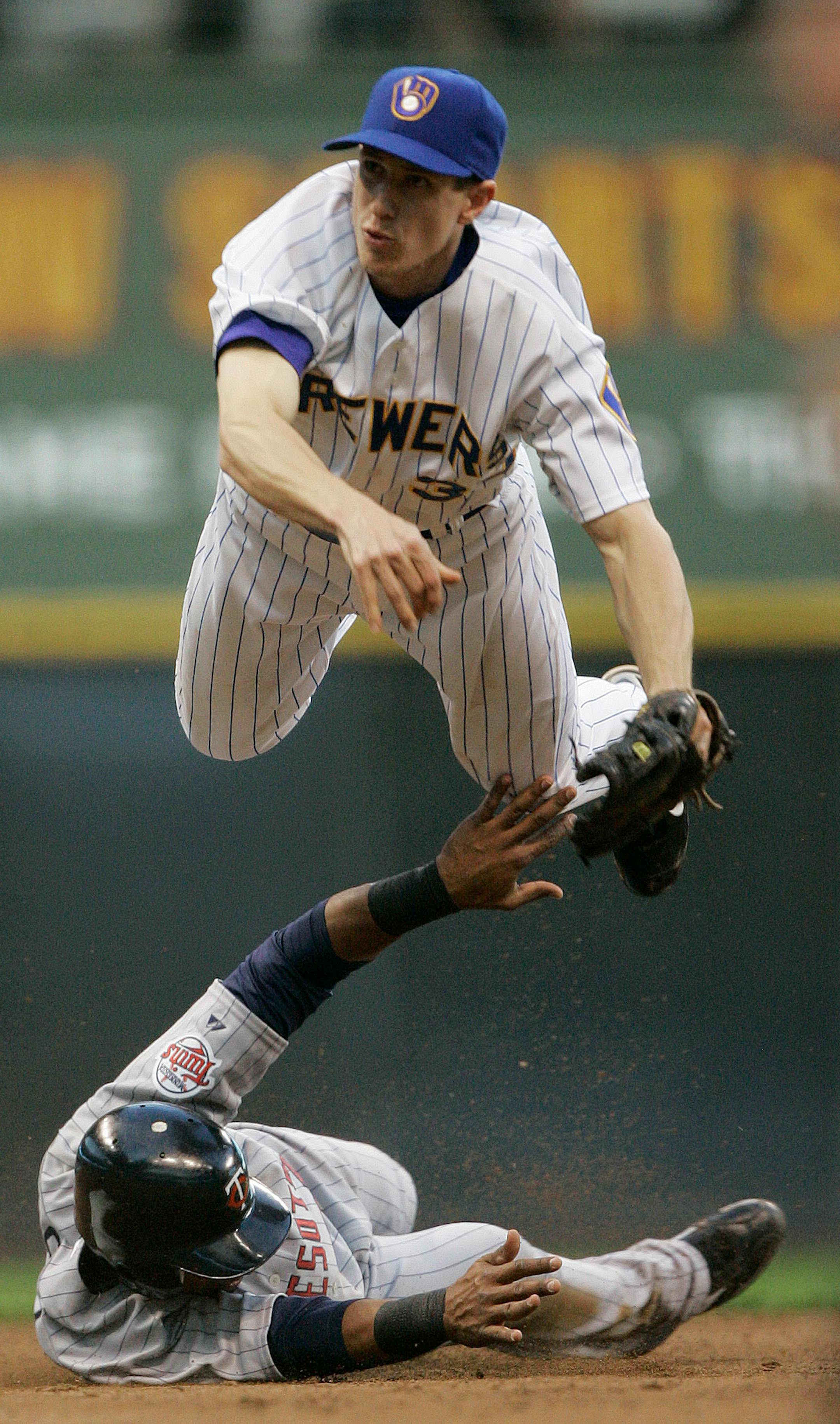 Milwaukee Brewers shortstop Craig Counsell, top, leaps over Minnesota Twins' Alexi Casilla to try and complete a double play on a ball hit by Twins' Joe Mauer during the fifth inning of a baseball game Friday, June 13, 2008, in Milwaukee. Mauer beat the throw to first.