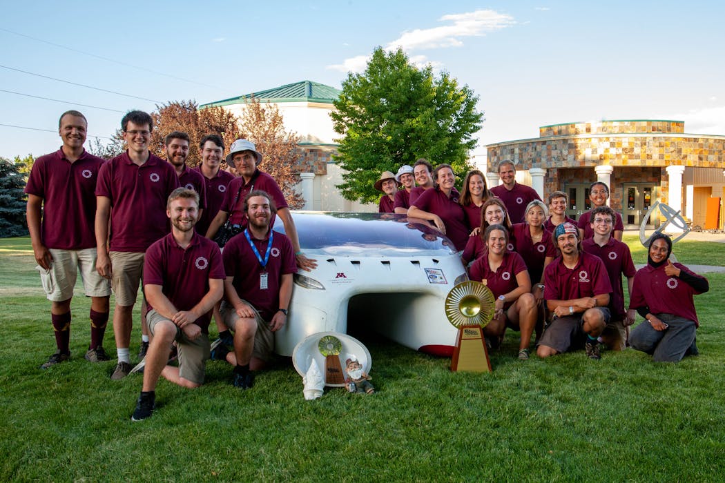 Team photo with the American Solar Challenge trophy and a few good-luck ornaments.