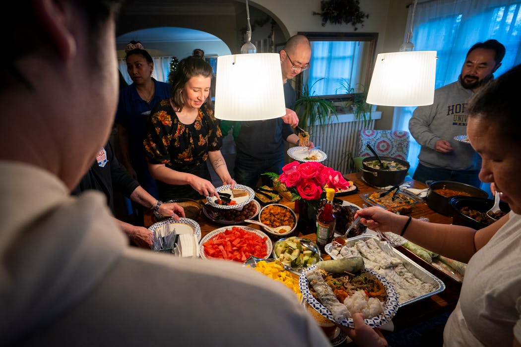Members of the BMPP giving circle fill their dinner plates at their annual year-end gathering at Kong and Kaohly Her’s house in St. Paul.