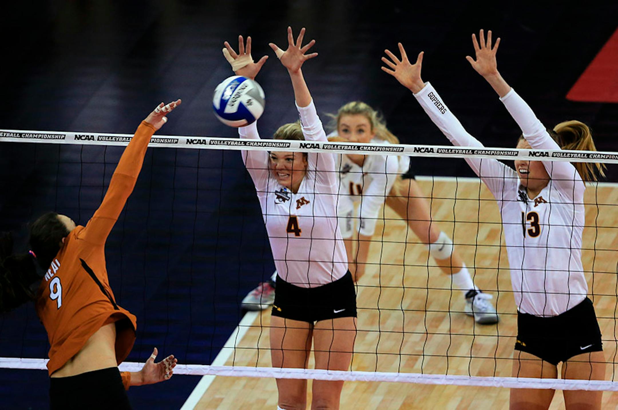 Texas' Amy Neal (9) h8ts a kill against Minnesota's Paige Tapp (4) and Molly Lohman (13) during an NCAA women's volleyball tournament semifinal in Omaha, Neb., Thursday, Dec. 17, 2015.