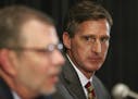 Former Syracuse athletic director Mark Coyle listens to University of Minnesota President Eric Kaler, left, as Coyle was introduced as Minnesota athle