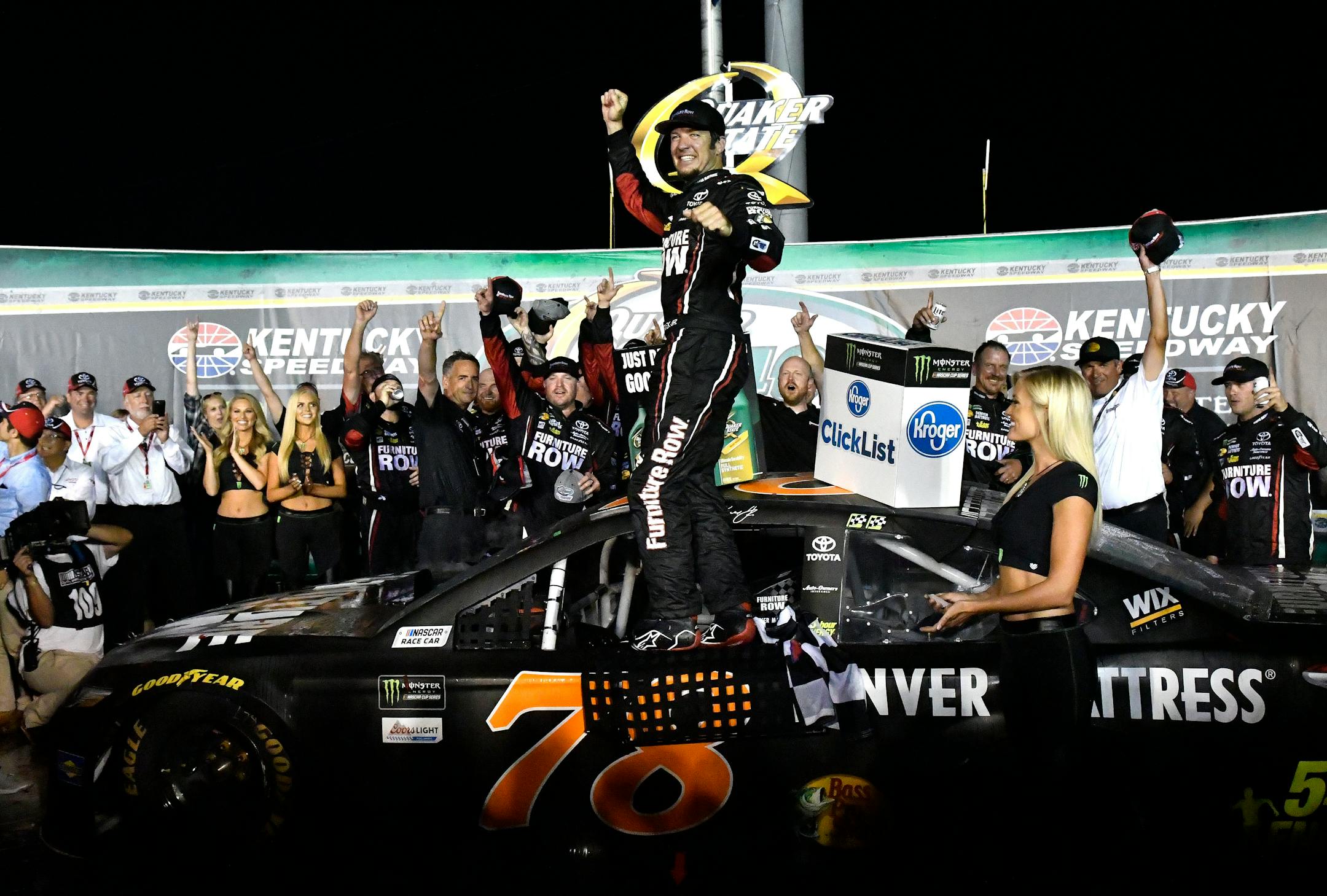 Martin Truex Jr. celebrates in Victory Lane following his victory in the NASCAR Cup auto race at Kentucky Speedway, Saturday, July 8, 2017, in Sparta, Ky. (AP Photo/Timothy D. Easley)