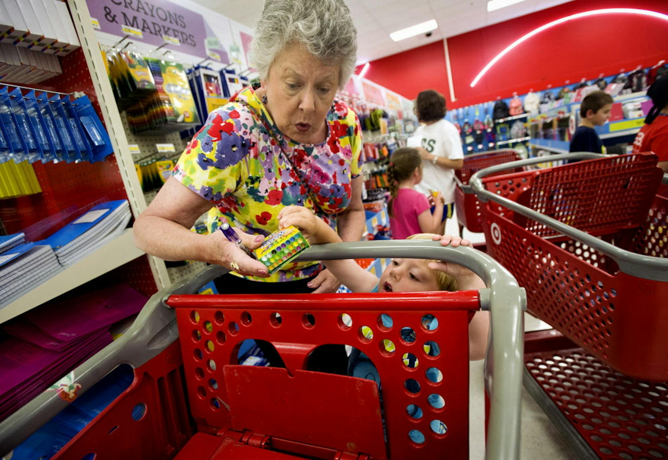 FILE - In this July 23, 2014 file photo, Julie Wilkins helps her grandson, Griffin Brady, 3, put a box of crayons in a shopping cart while shopping for school supplies with her family at a Target store in Memphis, Tenn. Target reports quarterly financial results on Wednesday, Nov. 19, 2014. (AP Photo/The Commercial Appeal, Brandon Dill, File)