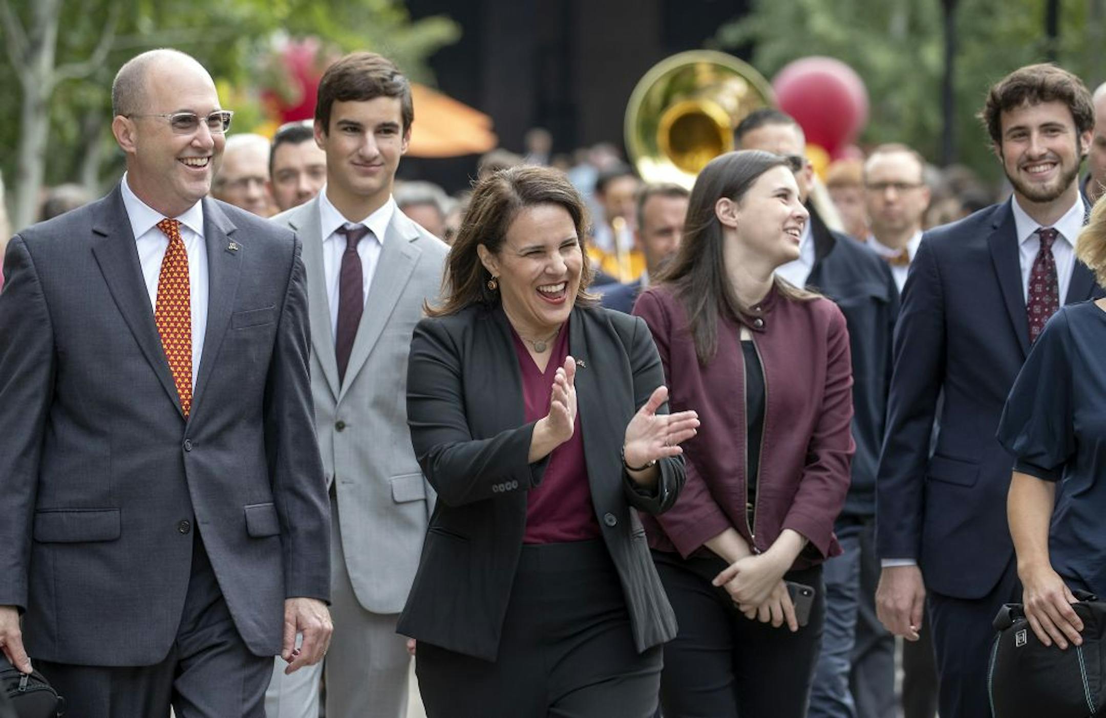 Followed by her family including her husband, Dr. Gary Gabel, left, Joan Gabel, the University of Minnesota's first female president, greeted many during the "Procession to Scholars Walk, as she made her way to the steps of Northrop Memorial Auditorium for welcome remarks, Friday, September 20, 2019.
