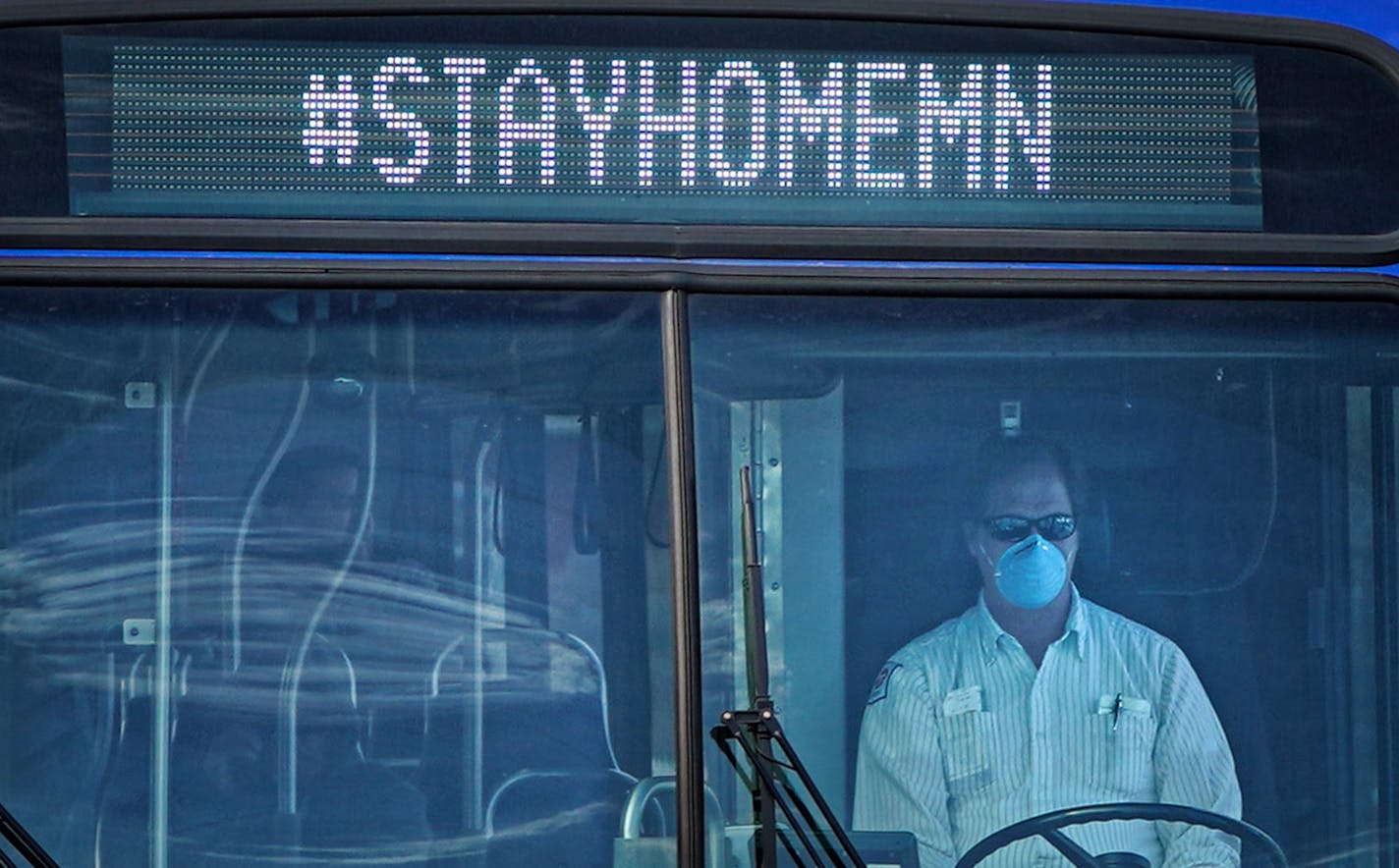 A masked Metro Transit driver ran his route along Snelling Avenue at Grand Ave in St Paul Sunday afternoon, April 5, 2020.