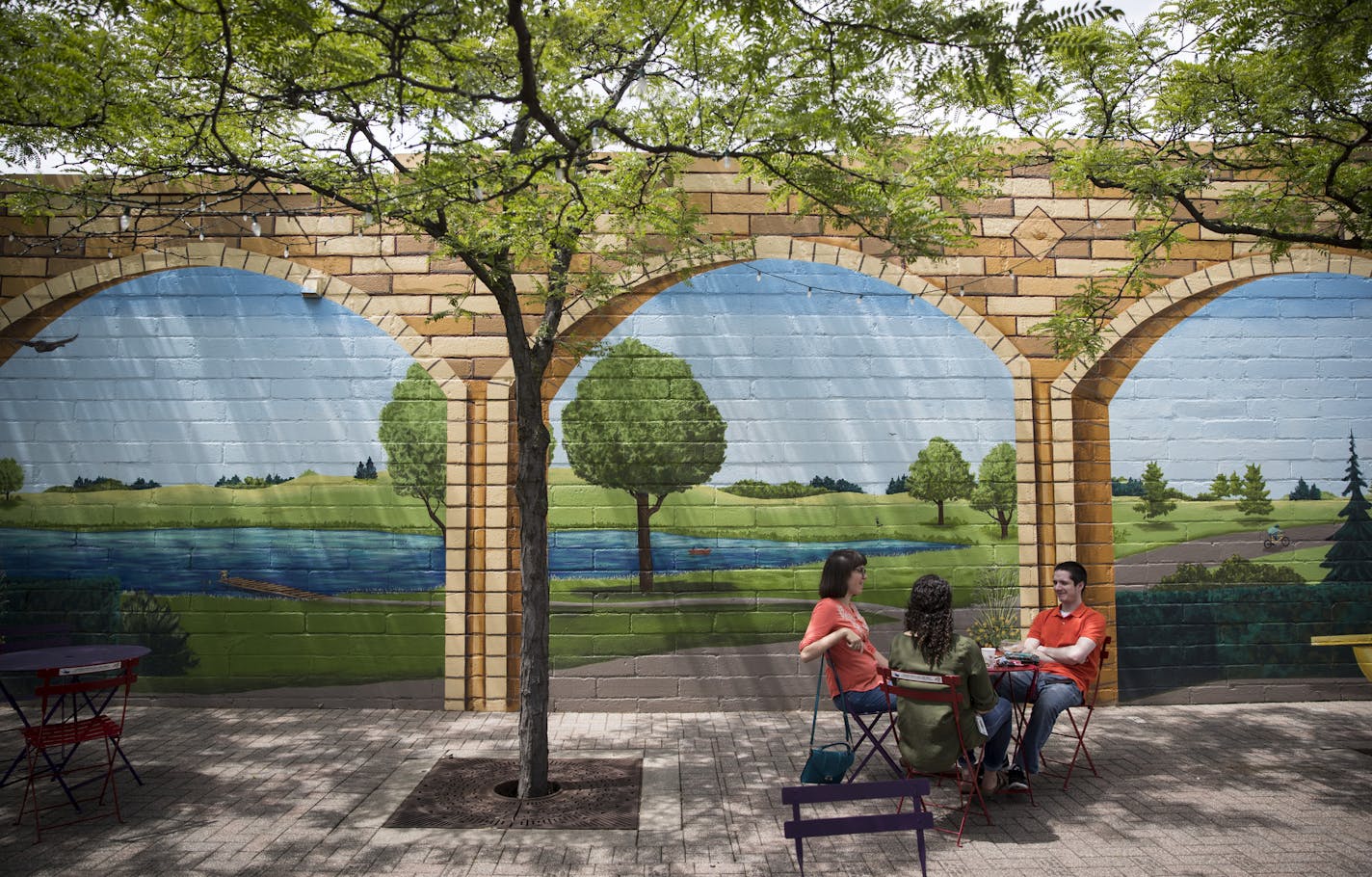 Ella Rasp, Rachel Auerbach and Kyle Flanegin took a donut break in a plaza with a mural in downtown Robbinsdale, Minn., on June 30, 2017. ] RENEE JONES SCHNEIDER &#x2022; renee.jones@startribune.com