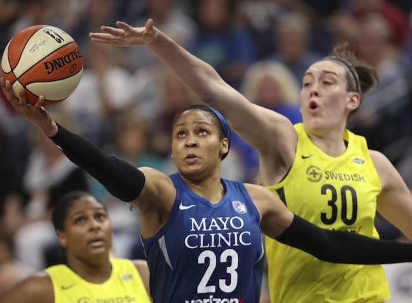Minnesota Lynx forward Maya Moore (23) shot under the hoop while defended by Seattle Storm forward Breanna Stewart (30) in the second quarter.