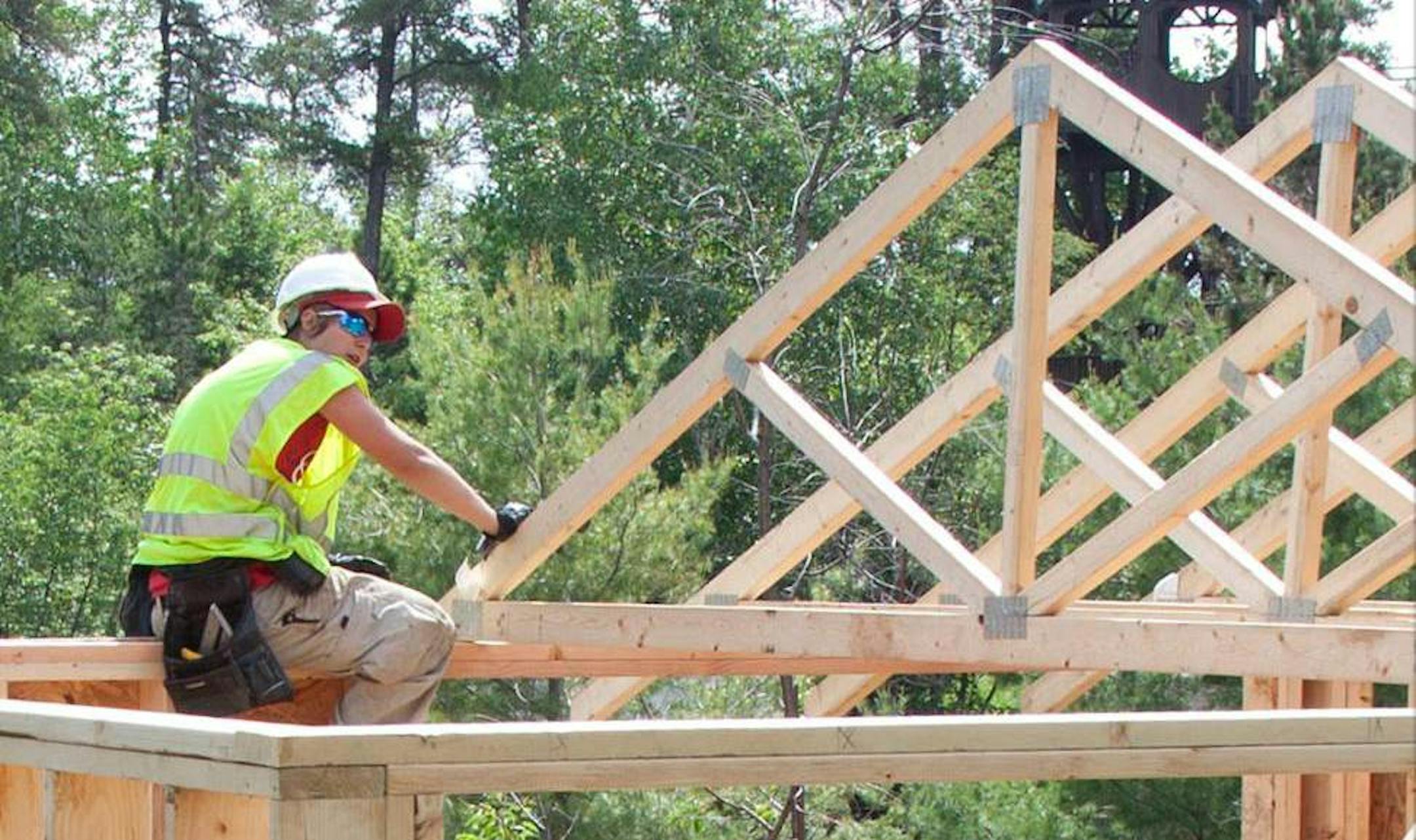 Jess Hill installs trusses for a cabin at Will Steger's retreat center near Ely.
